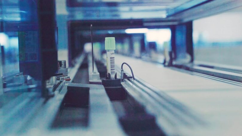 Automated machinery with rails and a vertical component in a factory setting.